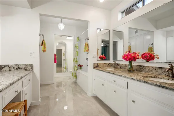 a bathroom with granite countertop shower sink and large mirror