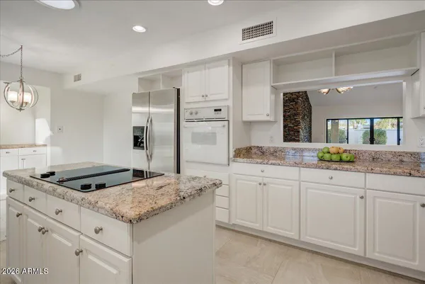 a kitchen with granite countertop a sink stove and refrigerator