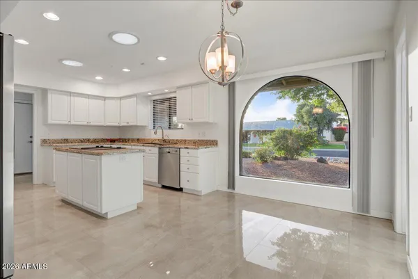 a kitchen with stainless steel appliances granite countertop a stove a sink and a refrigerator