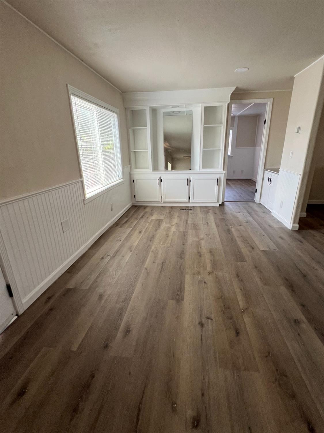 2110 Helm Avenue, Unit 48 Clovis, CA 93612 - Photo 4 of 9 an empty room with wooden floor and windows