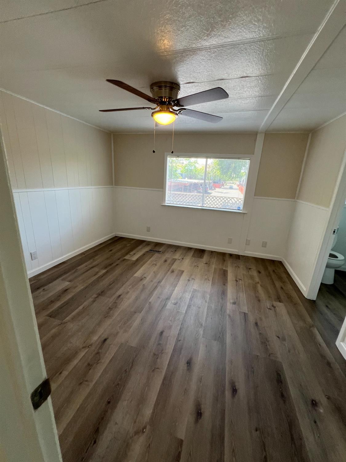 2110 Helm Avenue, Unit 48 Clovis, CA 93612 - Photo 5 of 9 an empty room with wooden floor and windows