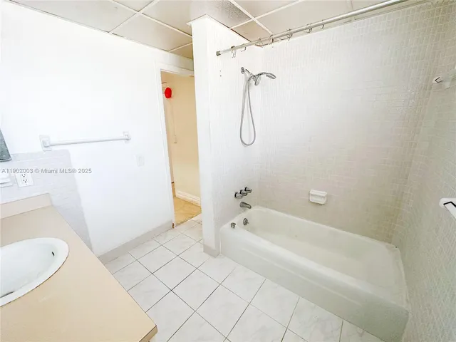 a bathroom with a tub a sink and a shower