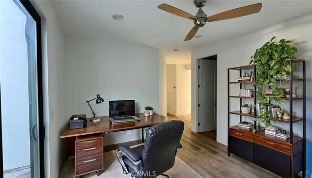 a view of a workspace with furniture and a window