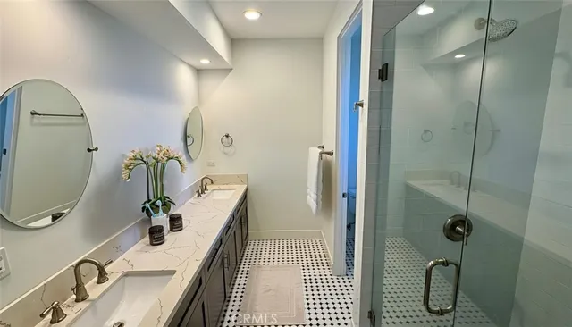 a bathroom with a sink a potted plant and shower