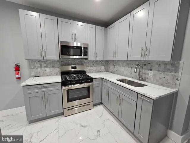 a kitchen with white cabinets stainless steel appliances and sink