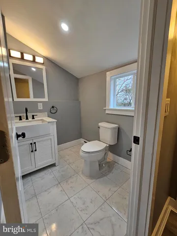 a spacious bathroom with a toilet sink and mirror