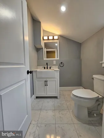 a bathroom with a sink toilet and mirror
