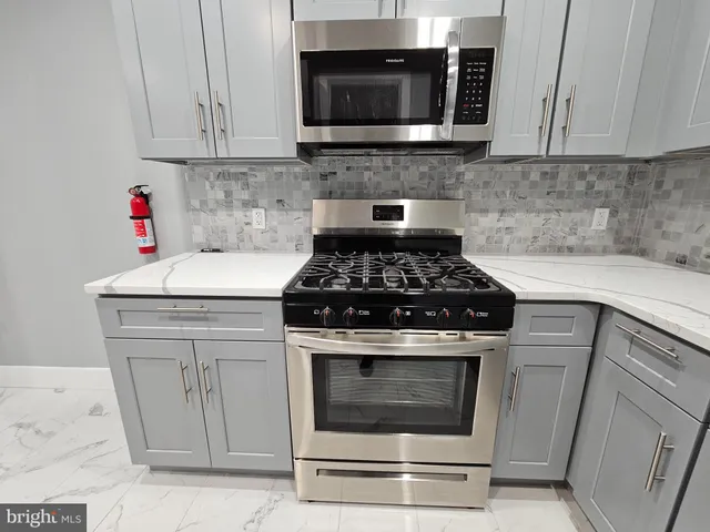 a kitchen with microwave a stove and cabinets