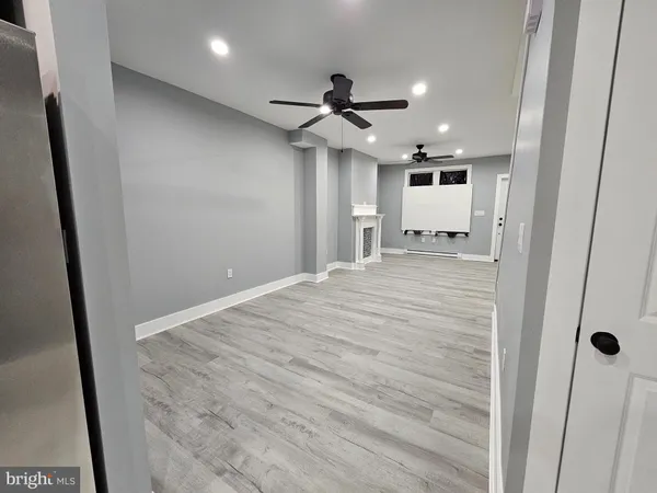 en empty room with wooden floor and ceiling fan