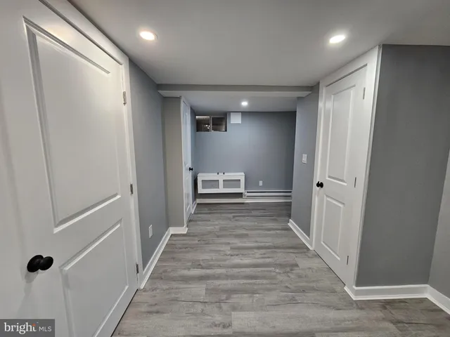 a view of a hallway with wooden floor and closet