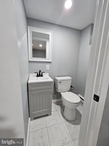 a bathroom with a toilet sink vanity and mirror