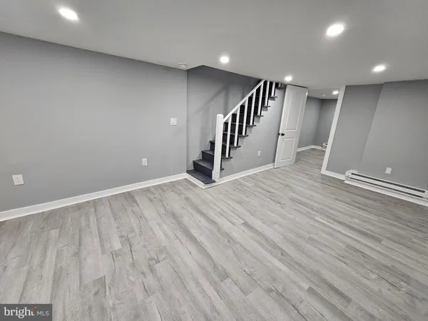an empty room with wooden floor and staircase