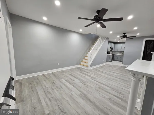a view of a room with wooden floor and a ceiling fan