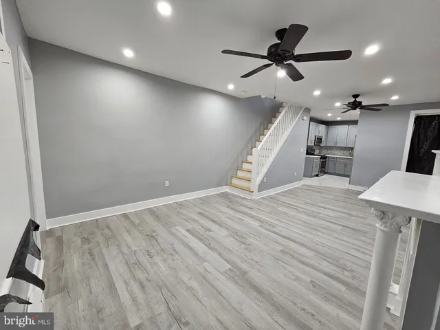a view of a room with wooden floor and a ceiling fan