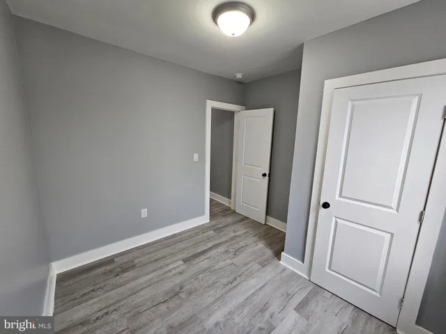 an empty room with wooden floor and entrance