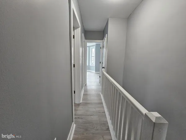 a view of a hallway with wooden floor and entryway