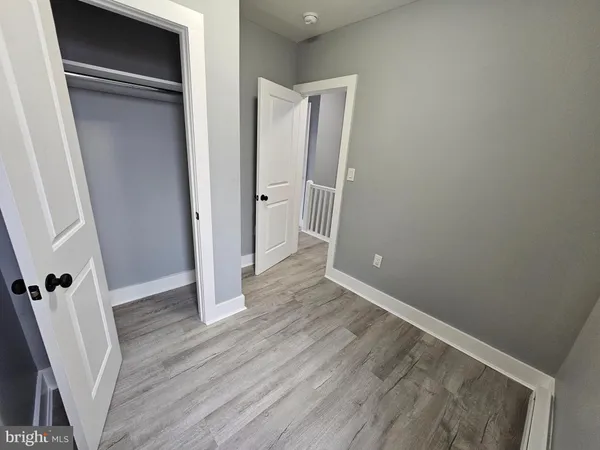 an empty room with wooden floor and entrance