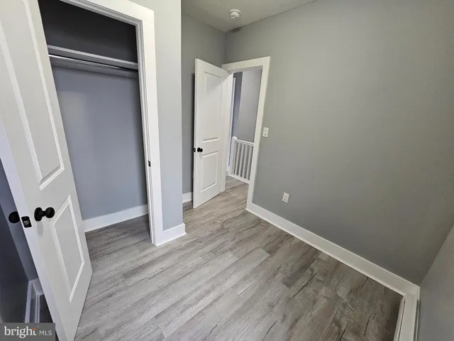 an empty room with wooden floor and entrance