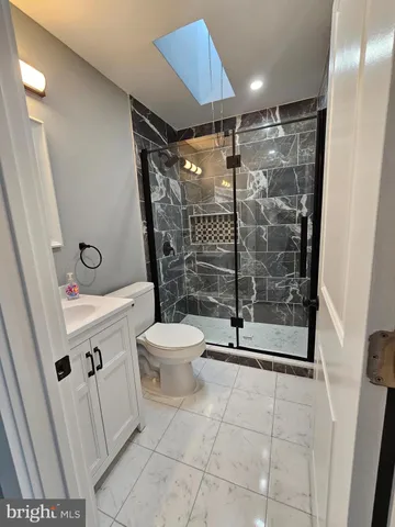 a bathroom with a shower a toilet and a sink