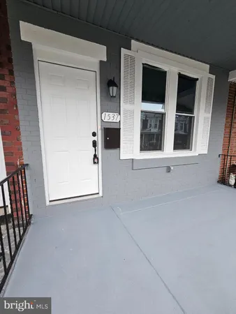 a front view of a residential apartment building with a yard and balcony