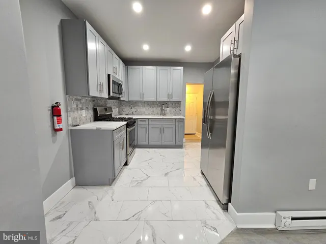 a kitchen with a sink a refrigerator and cabinets