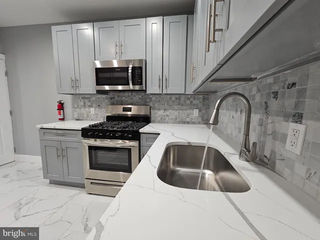 a kitchen with granite countertop a sink a stove and microwave