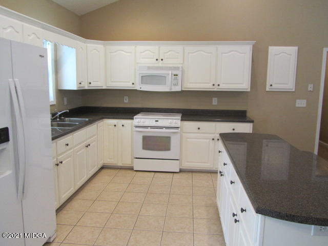 1383 Hamlin Road Lizella, GA 31052 - Photo 9 of 15 a kitchen with granite countertop white cabinets and white appliances