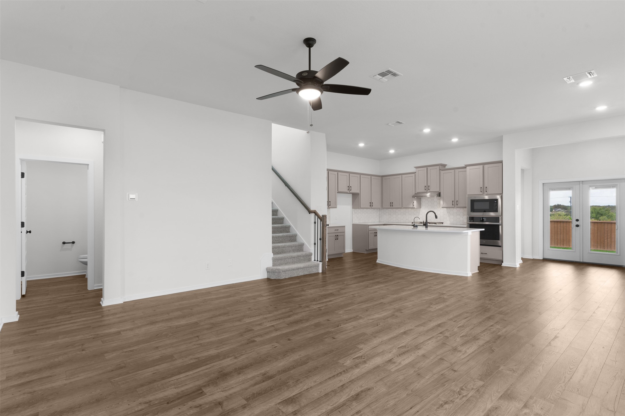 405 Raleigh Drive Georgetown, TX 78633 - Photo 6 of 27 Unfurnished living room with a ceiling fan, recessed lighting, dark wood-type flooring, and french doors