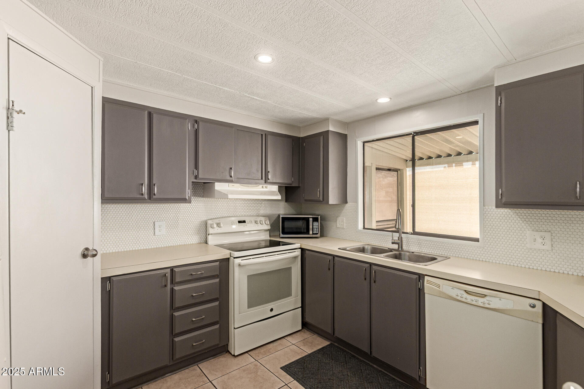 301 South Signal Butte Road, Unit 706 Apache Junction, AZ 85120 - Photo 17 of 48 a kitchen with a sink stove and cabinets