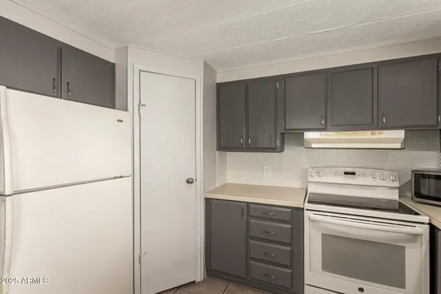 a kitchen with a refrigerator a sink and chairs