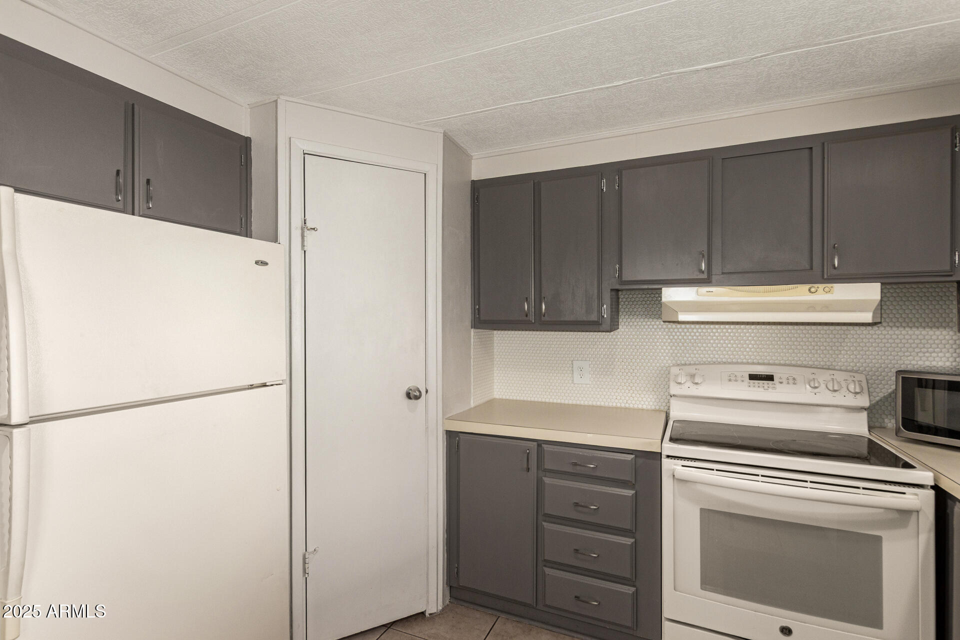 301 South Signal Butte Road, Unit 706 Apache Junction, AZ 85120 - Photo 19 of 48 a kitchen with a refrigerator sink stove and cabinets