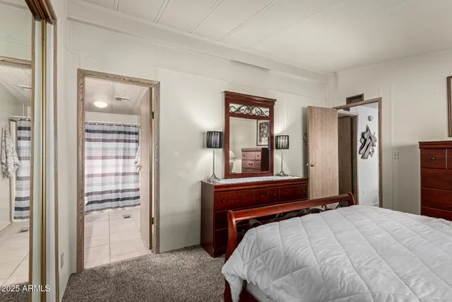 a large bedroom with a bed a table and chair