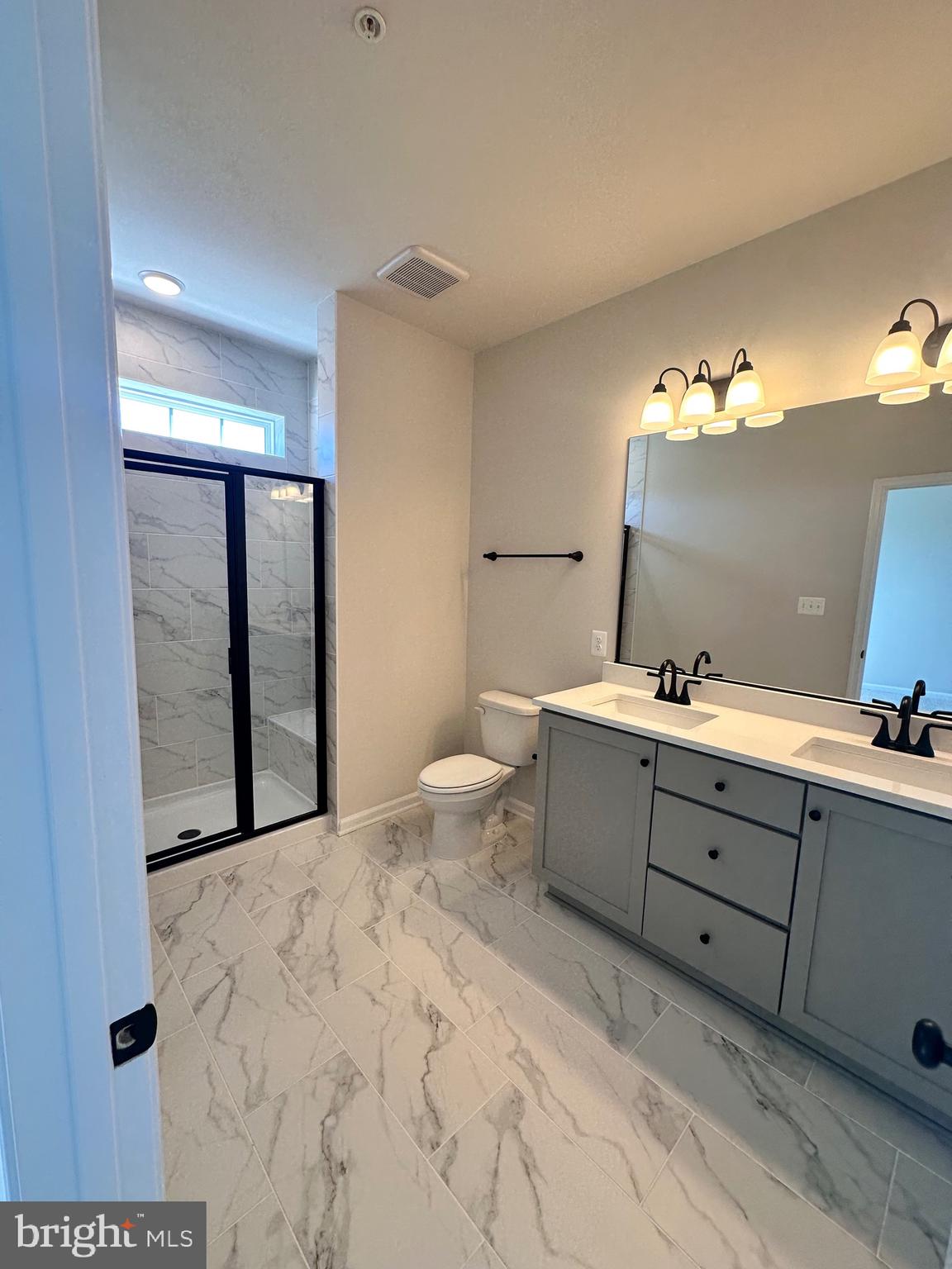 108 Spring Bank Way Frederick, MD 21701 - Photo 11 of 19 a spacious bathroom with a double vanity sink toilet mirror and shower