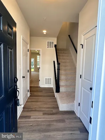 a view of a hallway with wooden floor and staircase