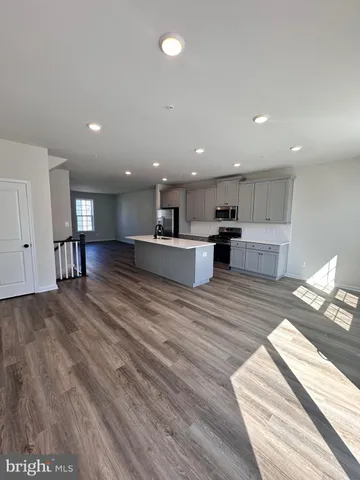 a view of kitchen with stainless steel appliances refrigerator sink and cabinets