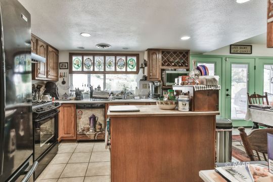 818 Lynn Way Ridgecrest, CA 93555 - Photo 6 of 22 a kitchen with stainless steel appliances granite countertop a stove and a refrigerator