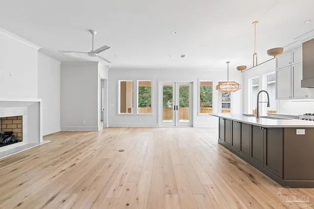 a view of an empty room with a kitchen and a window
