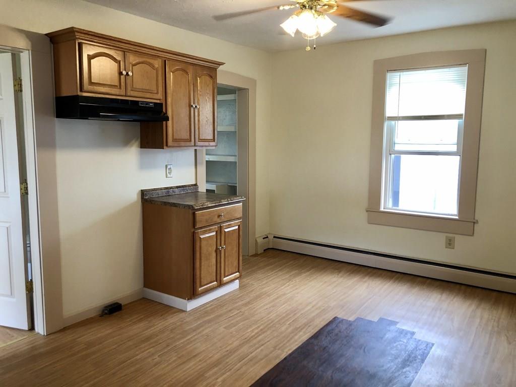 25 Baker Street Gardner, MA 01440 - Photo 9 of 26 an empty room with wooden floor cabinet and windows