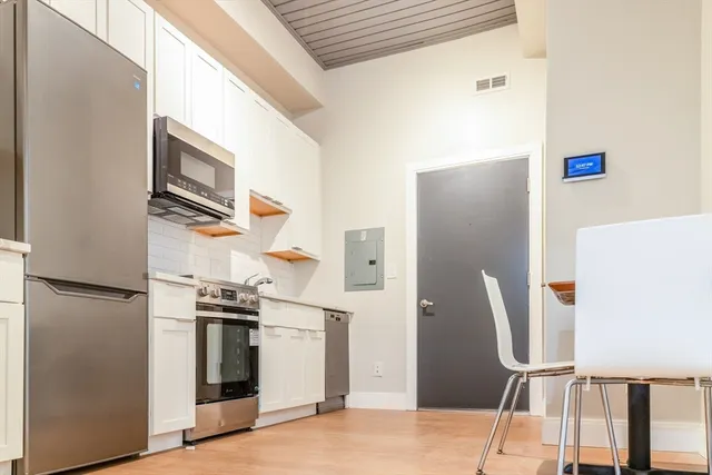 a kitchen with stainless steel appliances granite countertop a refrigerator and a stove