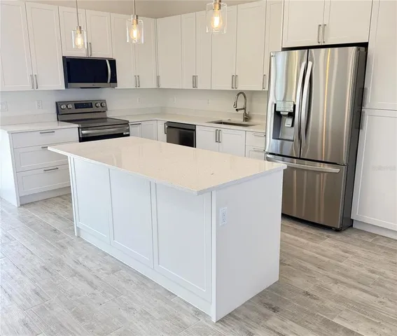 a kitchen with white cabinets and stainless steel appliances