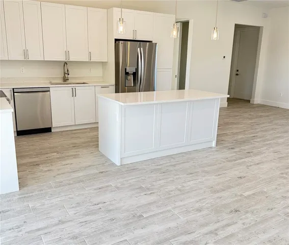 a kitchen with stainless steel appliances granite countertop a refrigerator a sink and a stove