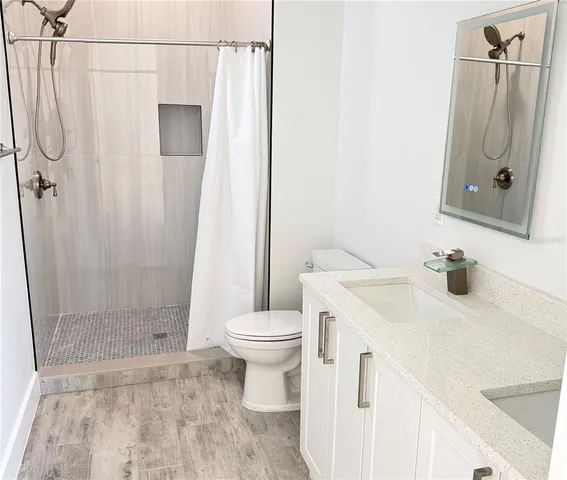 a bathroom with a sink a toilet and shower