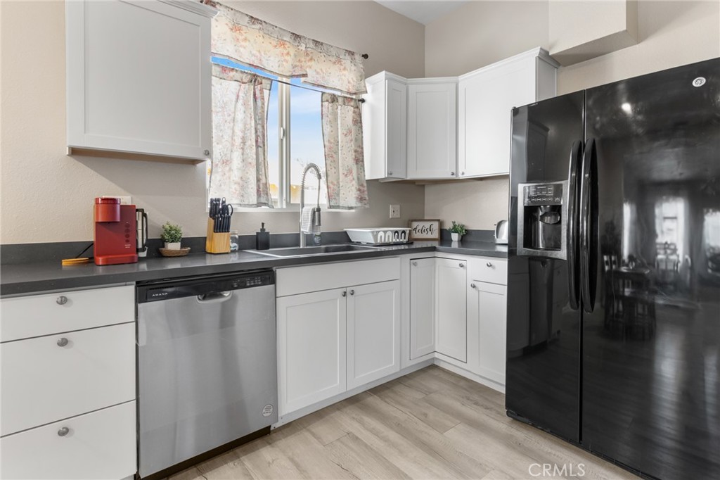 944 West 18th Street Merced, CA 95340 - Photo 10 of 34 a kitchen with a sink a refrigerator and cabinets
