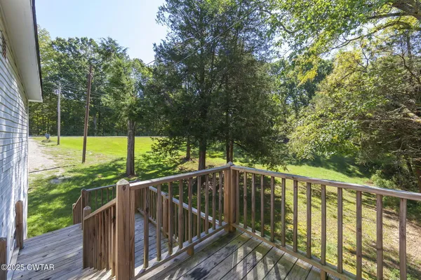 a view of a balcony with wooden floor and fence