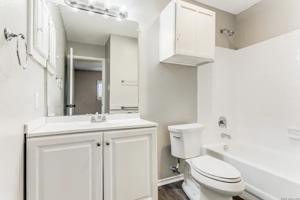 a bathroom with a toilet a sink and mirror