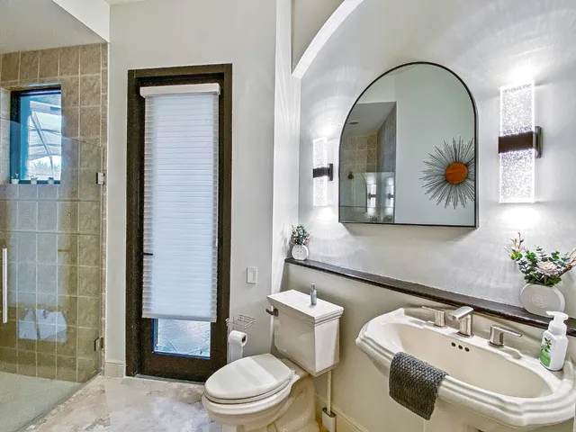 a bathroom with a toilet sink and mirror