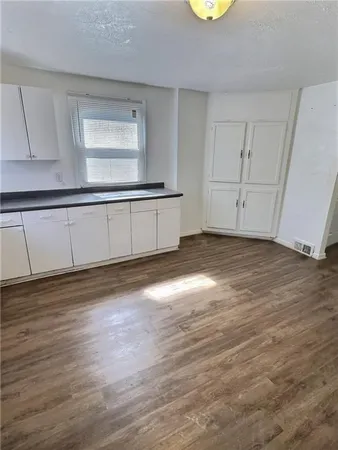 a view of a room with wooden floor and cabinet