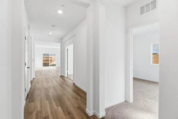 a view of a hallway with wooden floor and closet