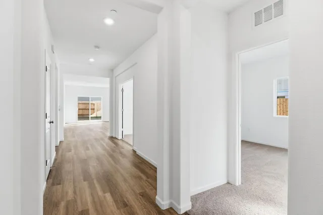 a view of a hallway with wooden floor and closet