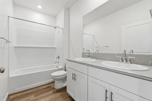 a bathroom with a double vanity sink toilet mirror and shower